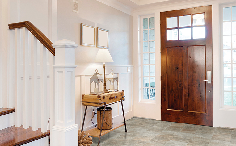 natural stone look luxury vinyl tile in modern entryway with wood accents